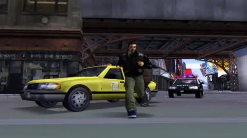 Protagonista de GTA 3 corre ao lado de um táxi amarelo e de uma viatura da polícia numa rua de Liberty City