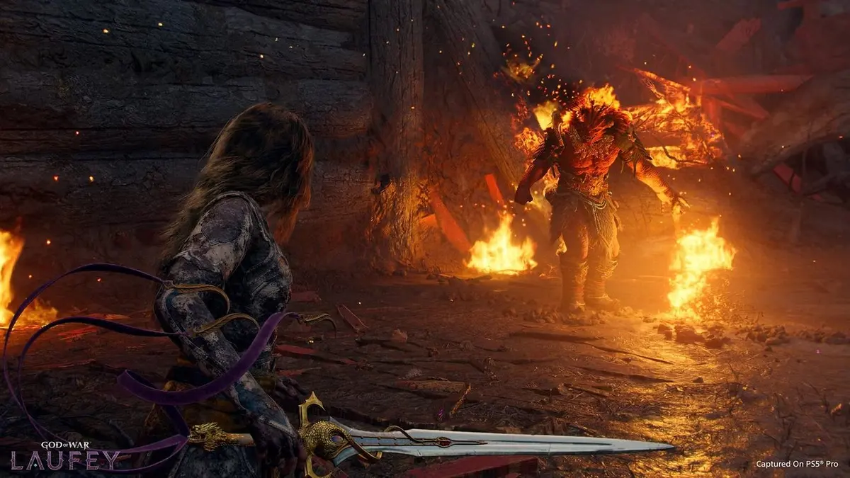 Cena de God of War Laufey: personagem com espada diante de um inimigo em chamas