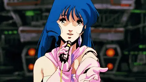 Lynn Minmay, personagem de Macross, canta ao microfone em cena do anime
