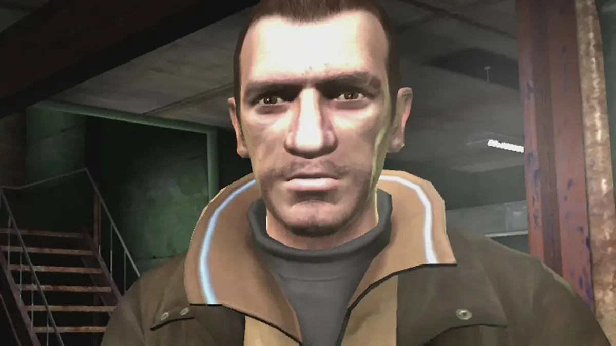 Niko Bellic, protagonista de GTA IV, em captura de tela do jogo, de jaqueta marrom em ambiente interno escuro