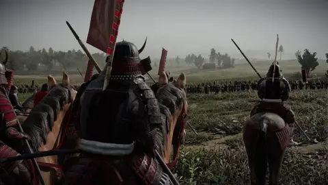Samurais com armaduras vermelhas e negras em cavalo, com bandeiras, em campo aberto durante uma batalha de Total War