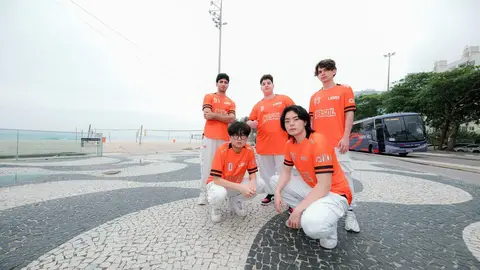 Jogadores da LOS posam no calçadão de Copacabana com uniforme laranja